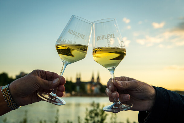 Weingläser beim Sonnenuntergang mit Mosel und Stadtkoblenz verschwommen im Hintergrund ©Koblenz-Touristik GmbH, Dominik Ketz