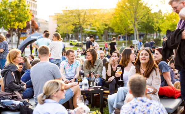 Personen mit Weingläsern in der Hand auf der Weinfestival-Veranstaltung Blaue Stunde - PopUp Weinbar vor der Rhein-Mosel-Halle Koblenz. © Koblenz-Touristik GmbH, Kai Myller