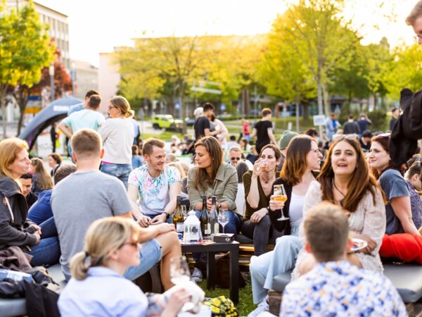 Personen sitzen bei der Blauen Stunde an der Rhein-Mosel-Halle in Koblenz &copy; Koblenz-Touristik GmbH, Kai Myller